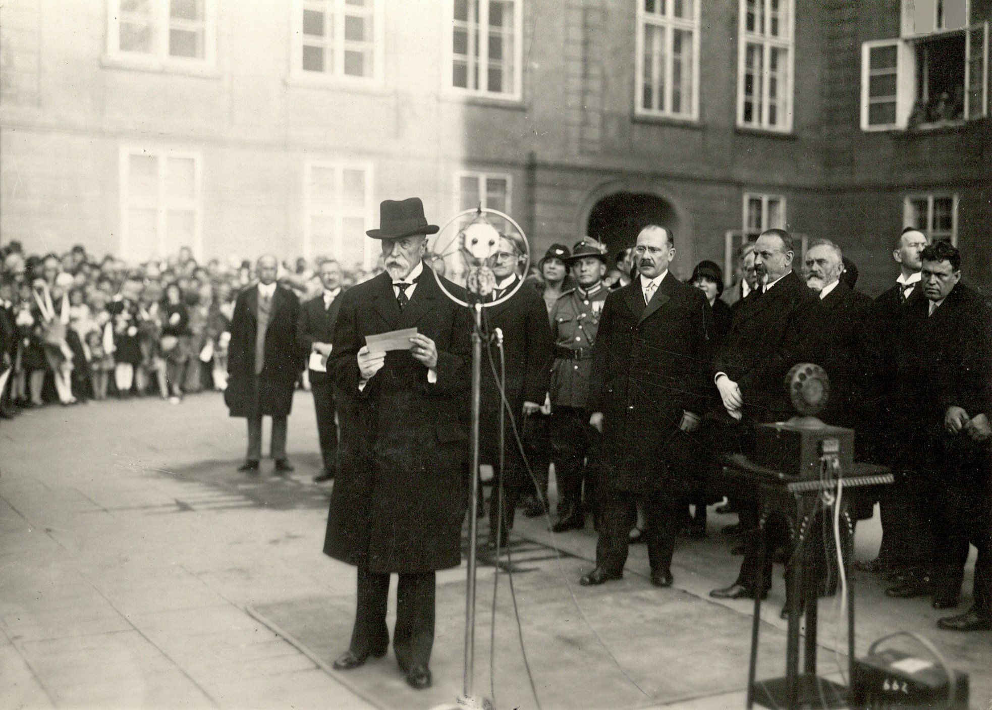 Prezident T. G. Masaryk hovoří ke školní mládeži. Rozhlasový přenos z Pražského hradu při oslavách 10. výročí republiky 27.10.1928, za Masarykem stojí ministr školství Milan Hodža a kancléř Přemysl Šámal