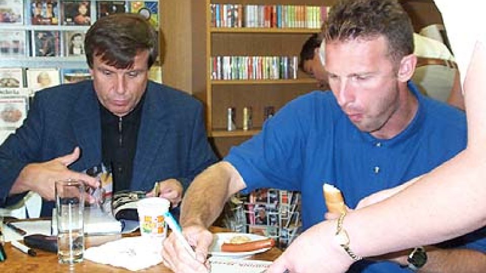 Hašek s Robertem Zárubou a s rohlíkem podepisuje knihu