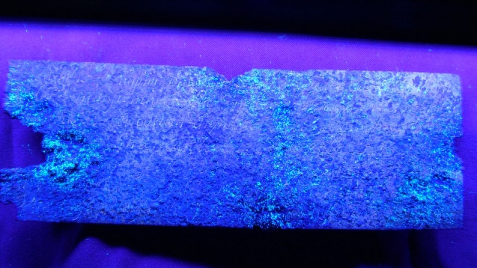 Kovová destička z hrobky Siarda Falka v UV světle