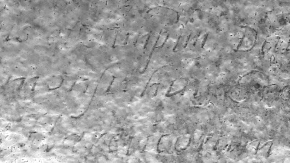 Detail písma na kovové destičce z hrobky Siarda Falka