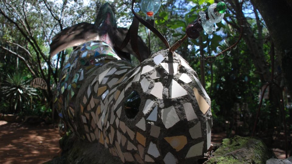 Šnek poskládaný z pestrobarevných střepů zdobí zahradu sklárny v Kitengele