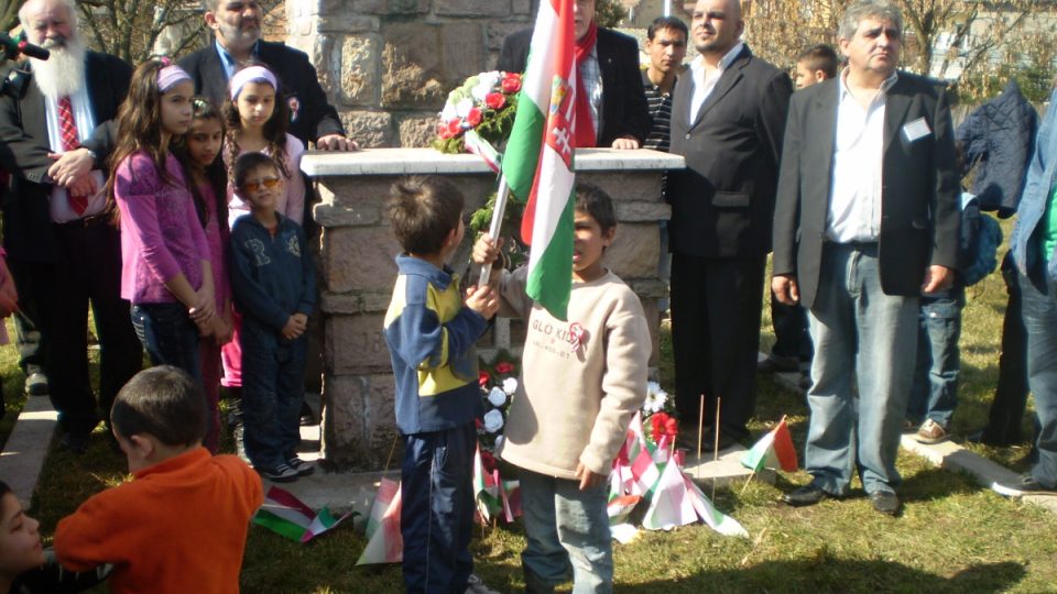Romské děti s maďarskou zástavou recitují revoluční báseň Hor’ sa Maďar! z roku 1848 