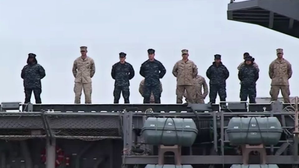 Tiše a důstojně se loučí američtí vojáci na palubě válečné lodi USS Bataan s domovem a svými rodinami na břehu