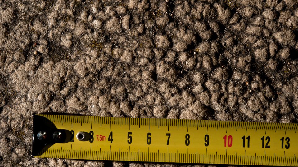 Povrch pískovce pokrytý zkamenělými jamkami po kapkách vody. Stáří cca 210 mil. let. Jamky jsou vypouklé, neboť se díváme na vrstvu, která je překryla. Jde tedy o odlitek.