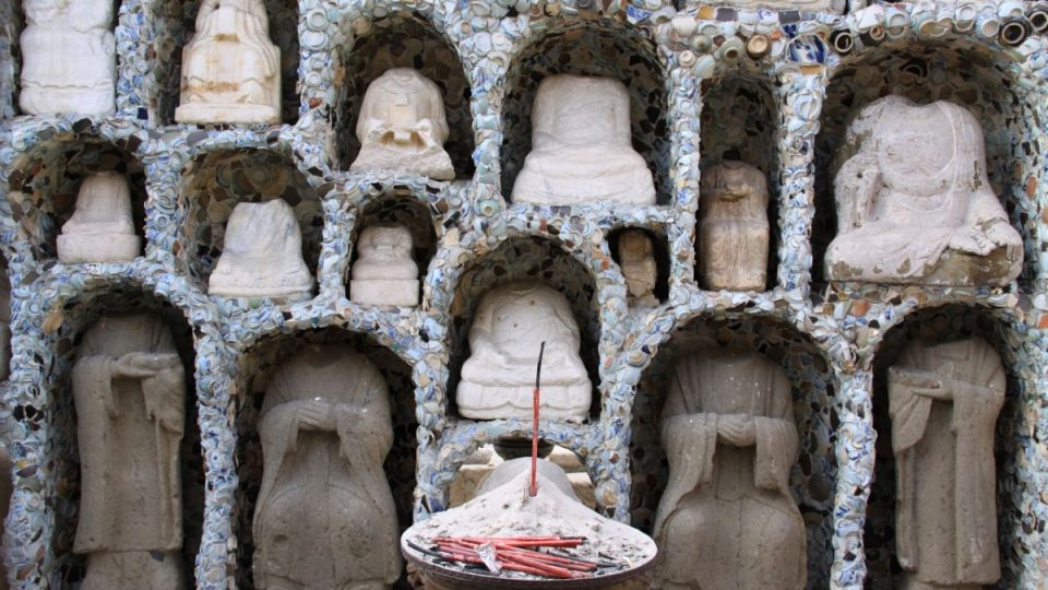 Za vstupní brankou do muzea se nachází řada nik vyplněných bezhlavými sochami Buddhů