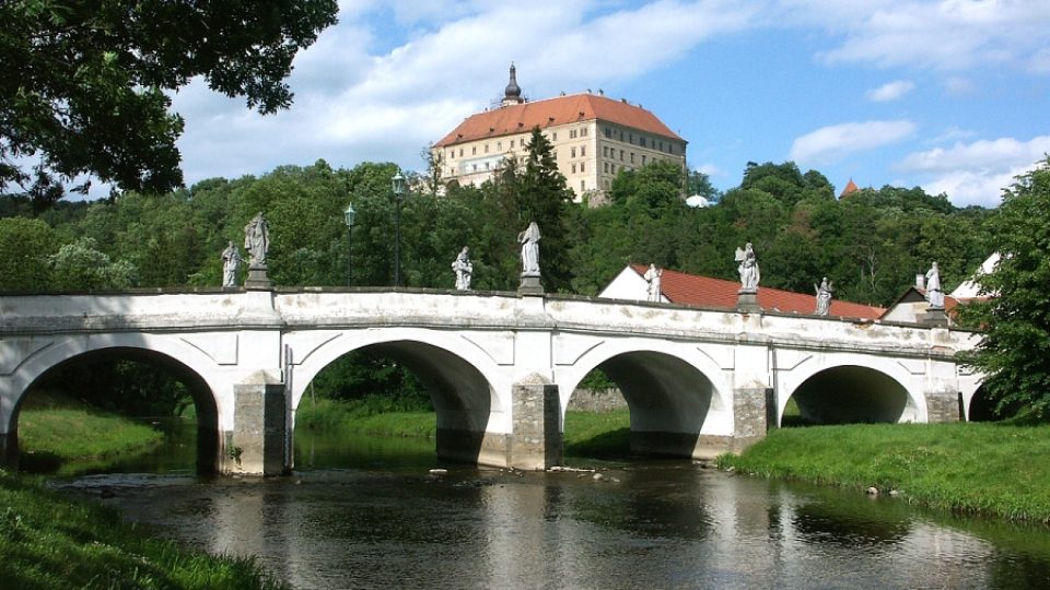 Zámek se tyčí nad řekou Oslavou a barokním mostem