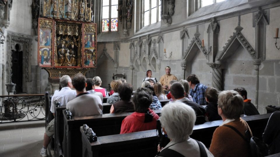 Návštěvníci křivoklátské kaple naslouchají výkladů průvodce se spoluprůvodkyní Kateřinou Cajthamlovou