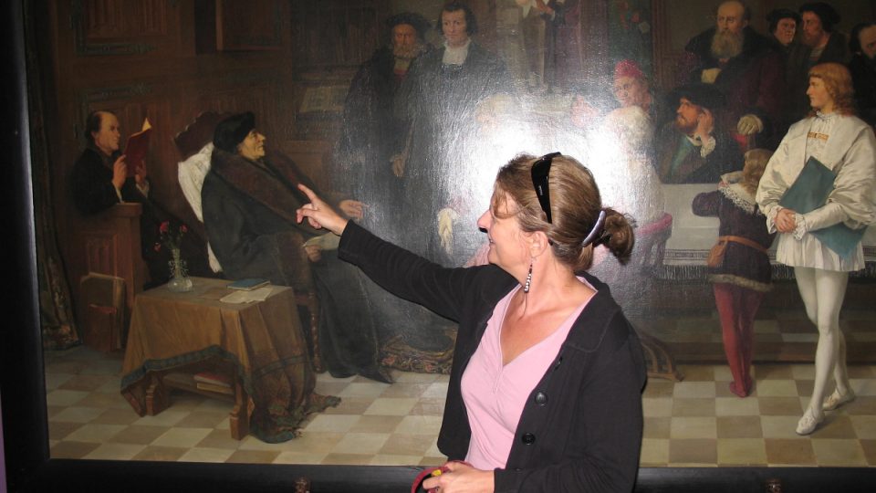 Kurátorka muzea Kathleen Leys ukazuje na sedící postavu Erasma Rotterdamského