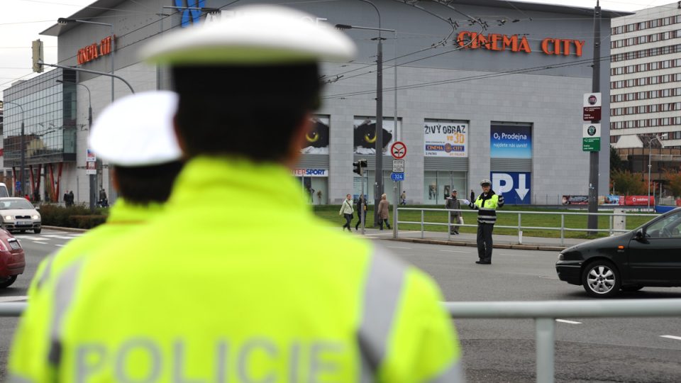 Policisté sledují svého kolegu při řízení křižovatky