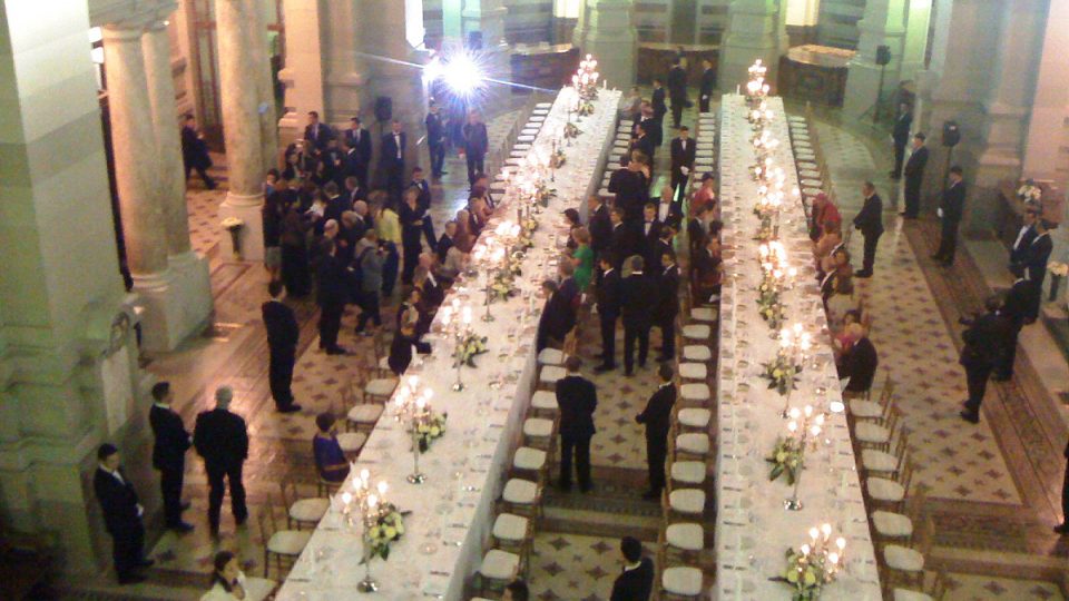 U stolů s mohutnými stříbrnými svícny a pozlaceným servisem se šikují desítky šlechticů, šlechtičen, princů a princezen