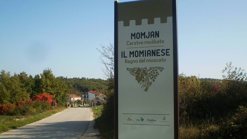 Návštevníka víta dvojjazyčná tabuľa, ktorá hlása, že Momjan je kráľovstvo muškátového vína