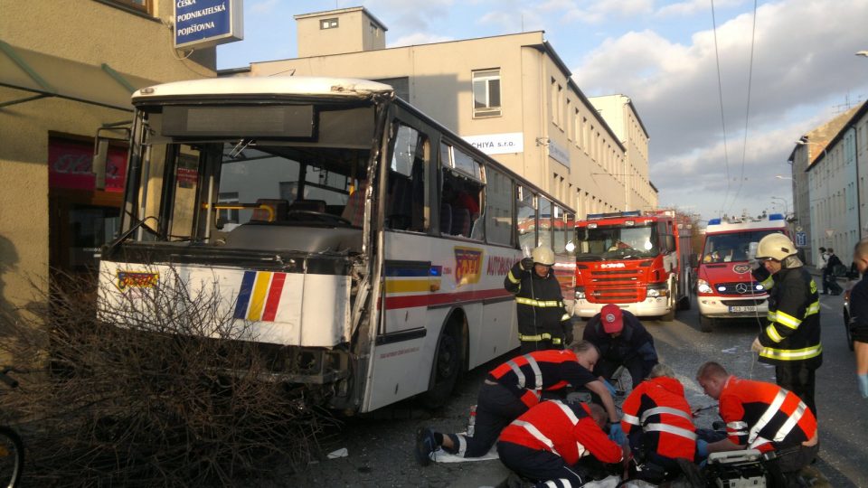 Záchranáři ošetřují zraněné po dopravní nehodě autobusu a trolejbusu.