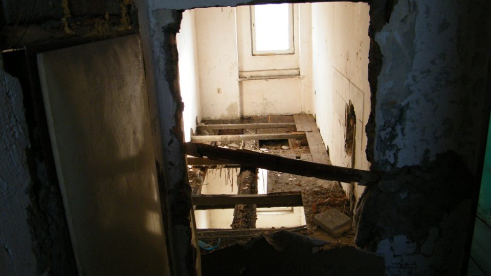 Ve druhém patře je propadlá podlaha. Ve vedlejším bytě žije osmičlenná rodina. 