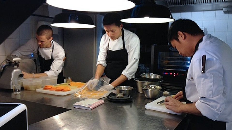 V malé kuchyni restaurace pracuje mezinárodní tým kuchařů