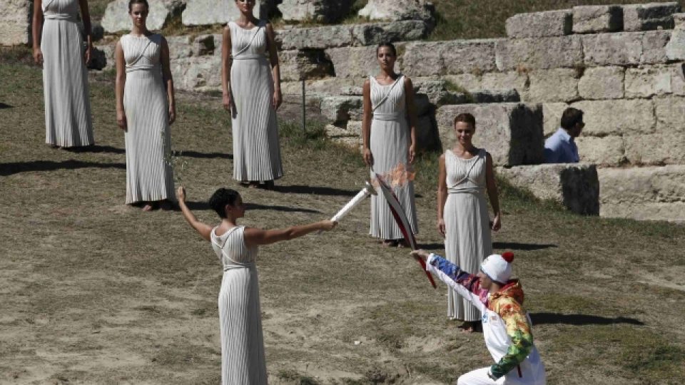 Řecký sjezdař Joannis Antoniu přebírá olympijský oheň od řecké herečky Ino Menegaki