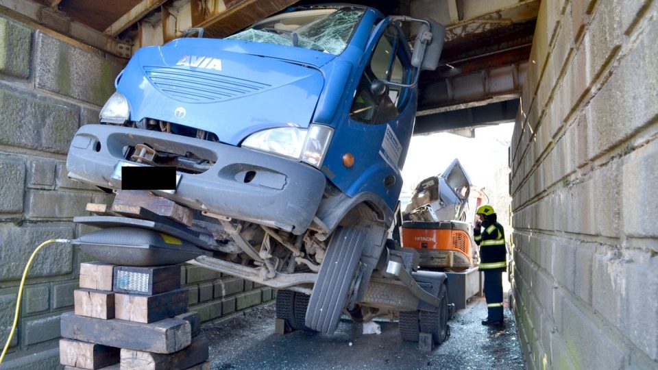 Kuriozní dopravní nehoda nákladního auta s bagrem