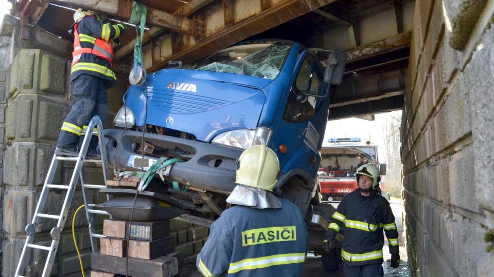 Kuriozní dopravní nehoda nákladního auta s bagrem