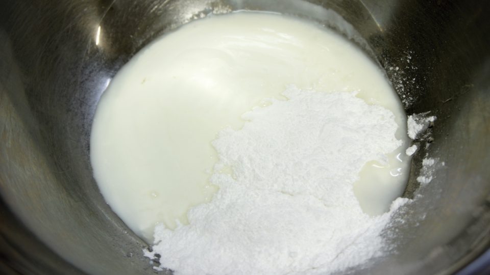 V misce rozmícháme jogurt, přidáme moučkový cukr a lžíci bílého rumu a pečlivě zamícháme