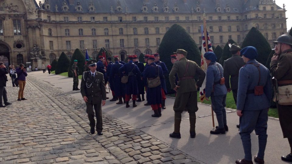 Dobrovolníci v uniformách cizinecké legie před slavnou budovou pařížské Invalidovny