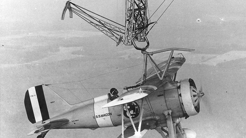 Stíhací bojový letoun F9C-2 Sparrowhawk připojený k hrazdě pod vzducholodí USS Macon (1933)