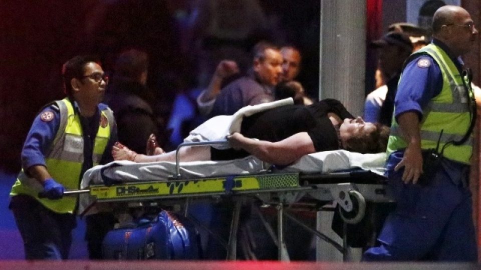 Záchranáři odvážejí zraněné rukojmí z kavárny v Sydney