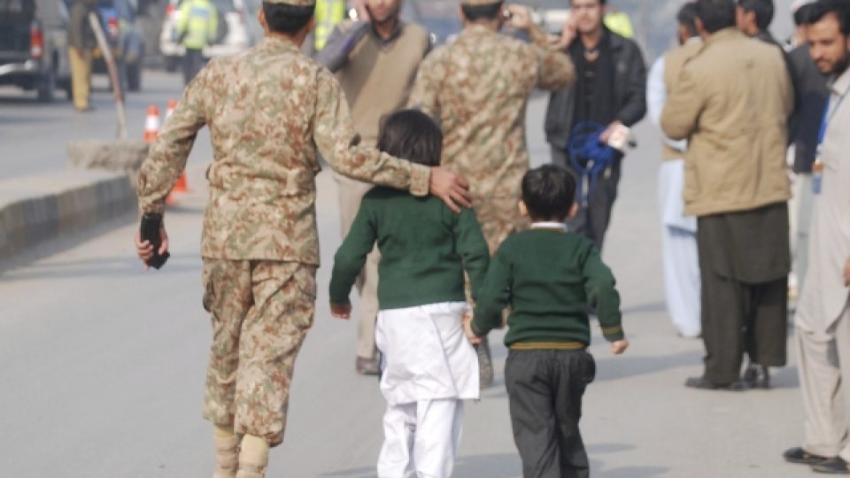 Pákistánský voják odvádí děti do bezpečí