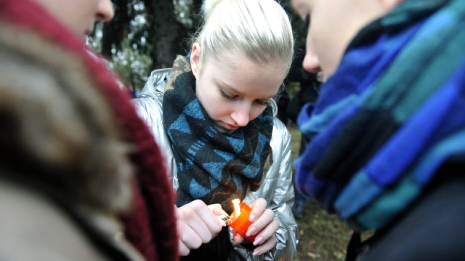 Dívka zapaluje svíčku u pietního místa v Uherském Brodě
