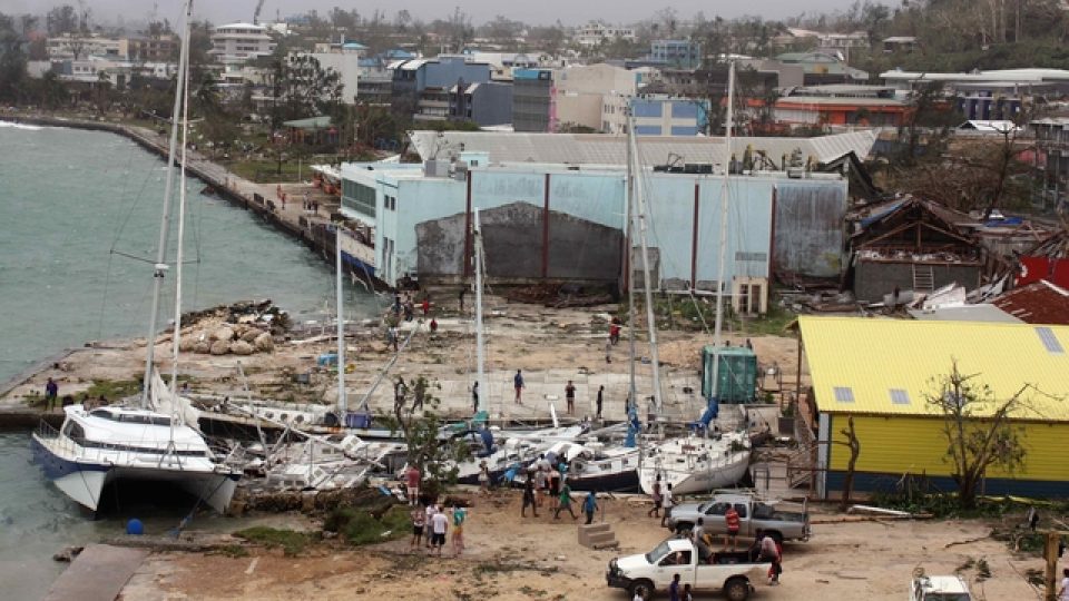 Lidé si prohlížejí poničené lodě v malé zátoce v hlavním městě Port Vila