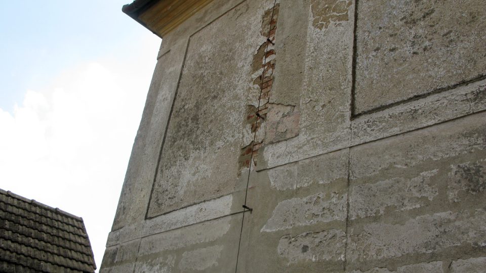 Ještě nerekonstruovaná zeď fary s náznakem červené omítky