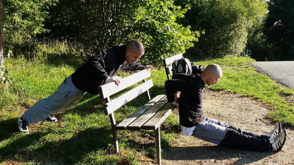 Marek Tomišek a David Popper cvičí na lavičce v parku