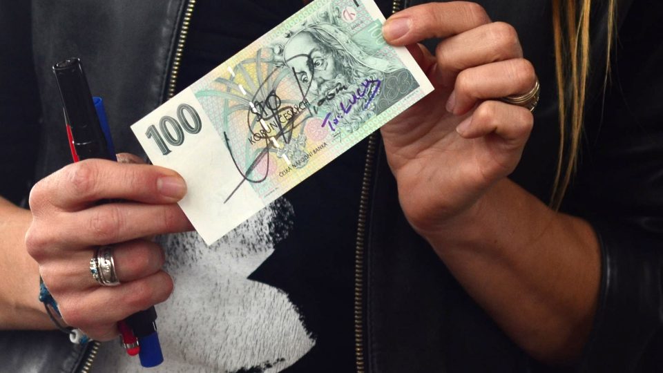 Lucie Výborná drží v ruce bankovku s podpisem Usaina Bolta