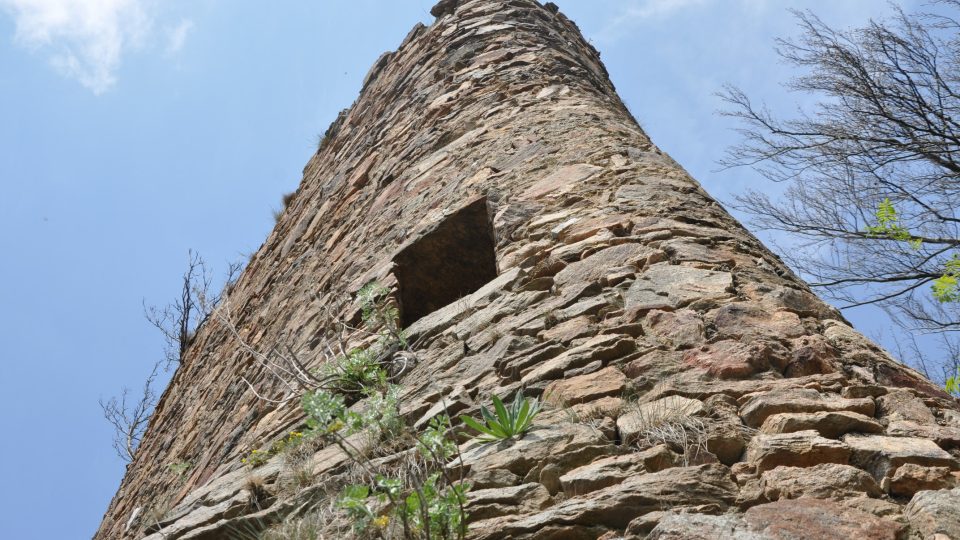 Věž zříceniny hradu Oheb stojí na skalnatém vrchu nad přehradou