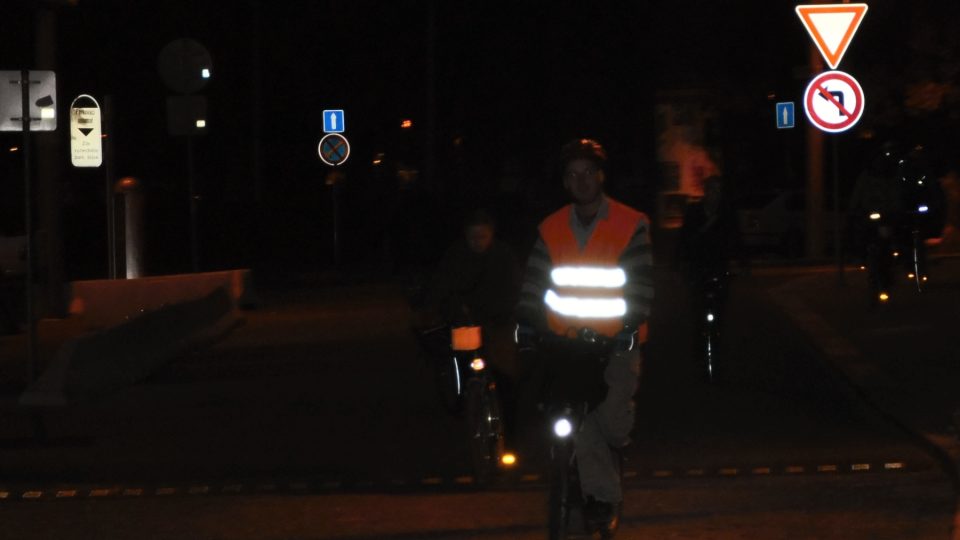 Ve tmě jsou na cyklistovi zdálky vidět jen reflexní prvky