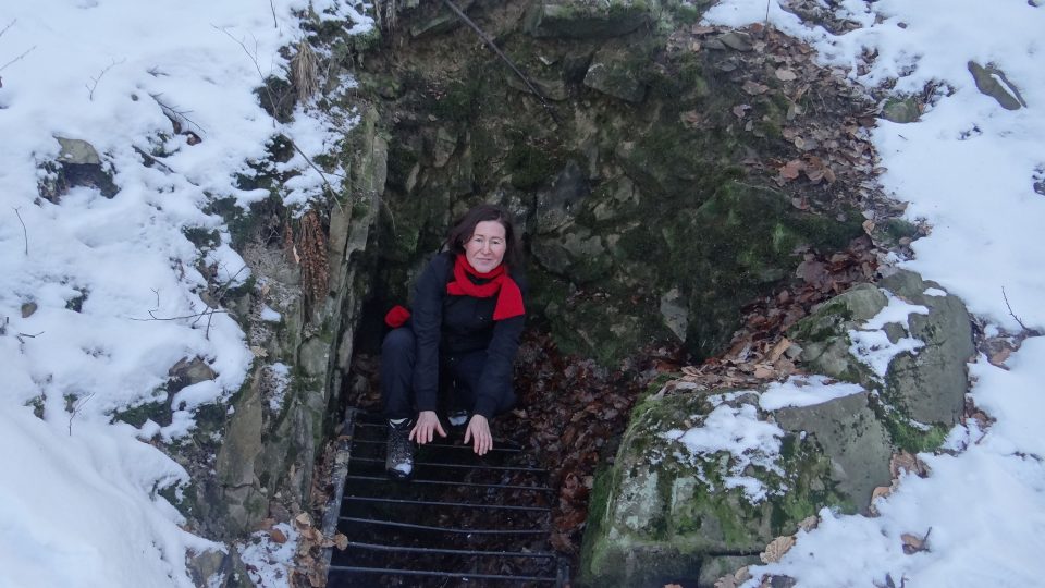 Eva Bucharová na mříži, která chrání vchod do Loupežnické jeskyně