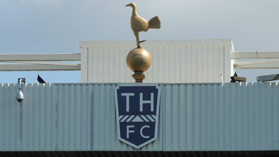 Kohout s typickou ostruhou (Spur) stojící na míči - tradiční znak Tottenhamu Hotspur, klubu založeného roku 1882