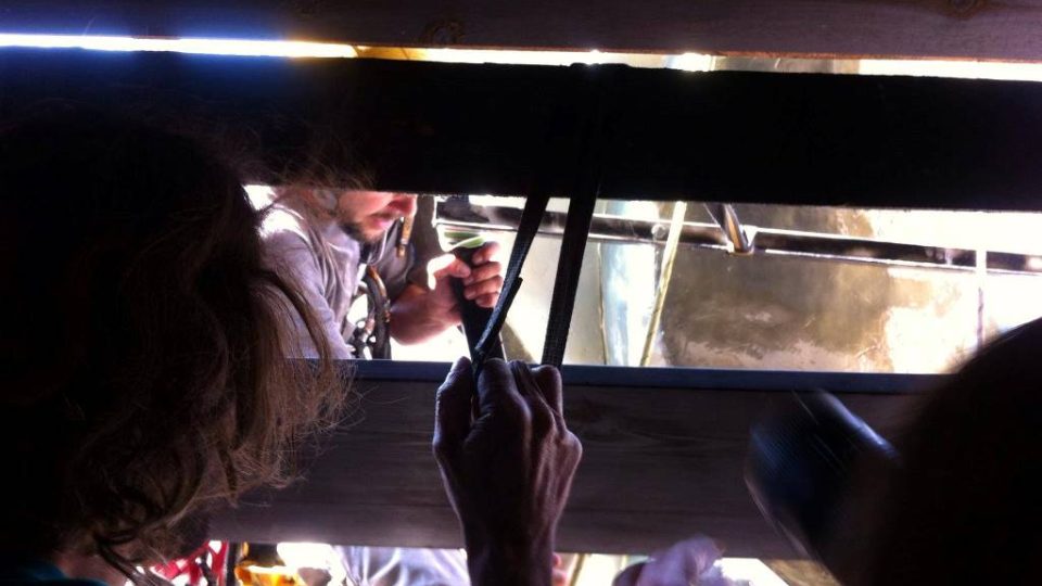 Připevňování obří mouchy Michala Trpáka do prostředního okna Černé věže v Českých Budějovicích