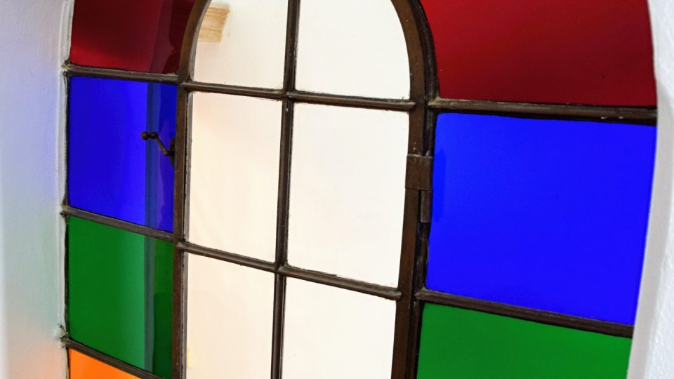 Barevná vitráž mezi dvěma schodišti