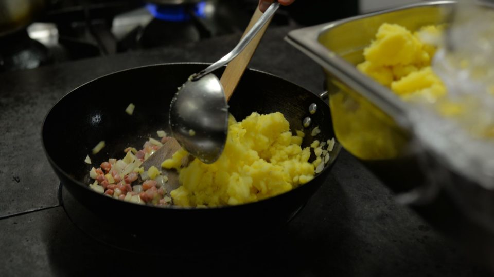 Přidáme najemno nakrájenou cibuli, nasekaný česnek a nakrájené uvařené brambory. Promícháme, dochutíme solí a pepřem a rozšťoucháme