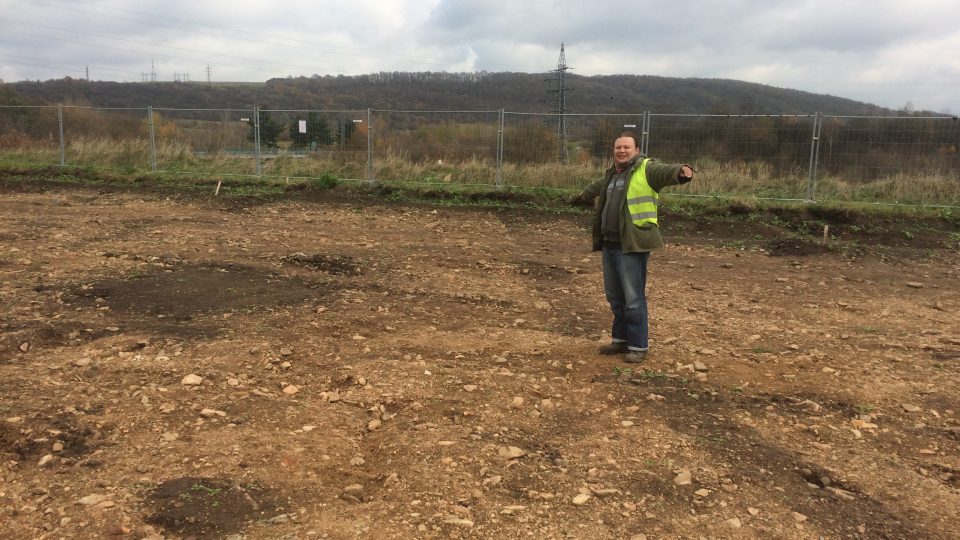 Archeolog Luboš Rypka na tmavých skvrnách ukazuje ohrazení palisádovými žlaby