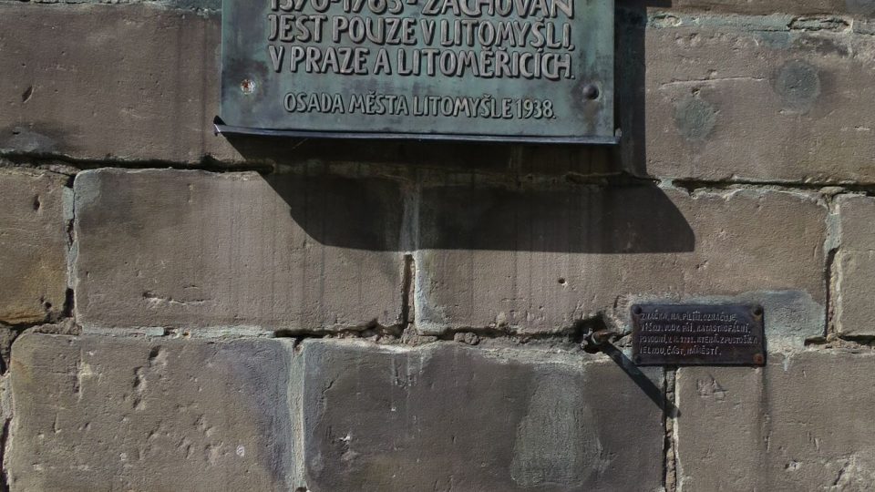 Bronzová deska nad zazděným českým loktem ve zdi radniční věže