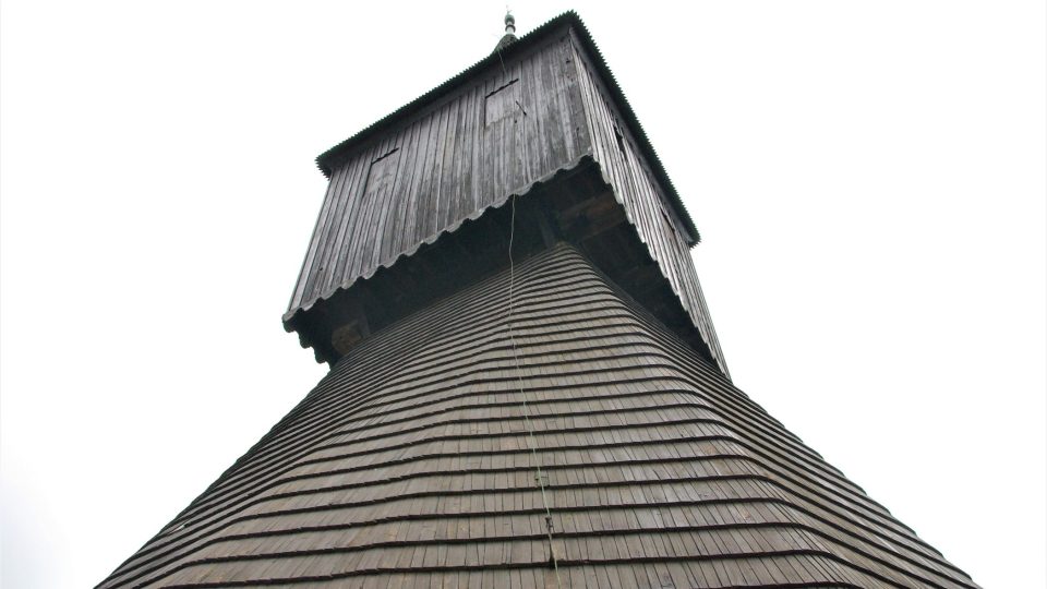 Polygonální stavba s šindelovou střechou ukrývá tři zvony