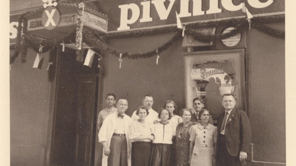 Slavnostní foto personálu s přáteli před vyzdobenou hospodou U Jelínků. Sokolský slet ve třicátých letech