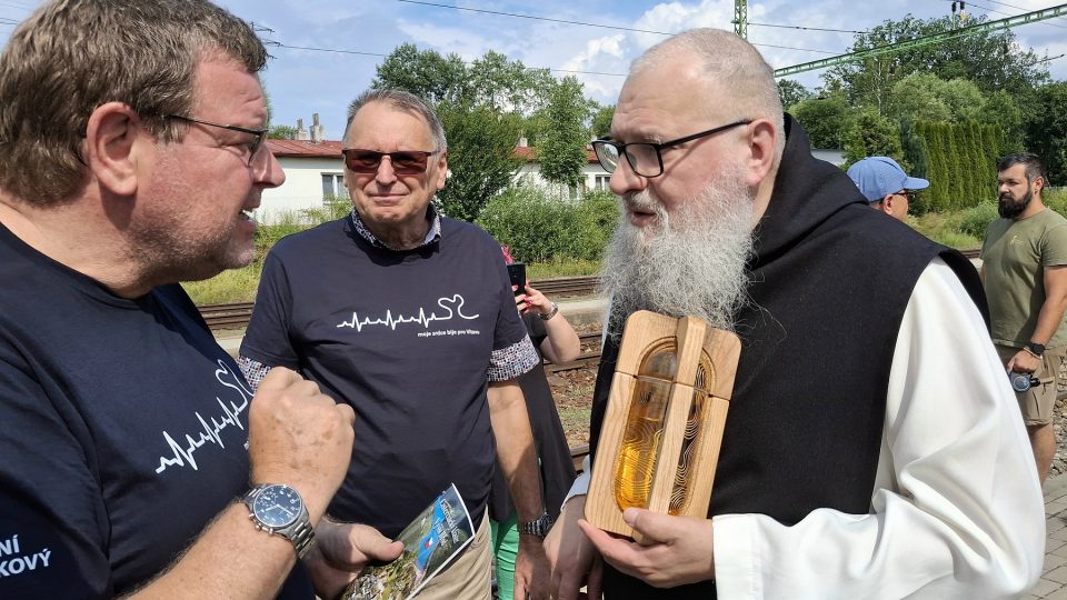 Převor Justin Berka přebírá štafetu kapsle posvěcené vody z pramene Vltavy z rukou ředitele Národního technického muzea Karla Ksandra | foto: Zdeněk Zajíček, Český rozhlas Převor Justin Berka přebírá štafetu kapsle posvěcené vody z pramene Vltavy z rukou ředitele Národního technického muzea Karla Ksandra