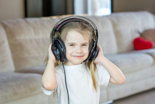 Dívka poslouchající hudbu,  sluchátka,  dítě | foto: Unsplash – Bermix Studio